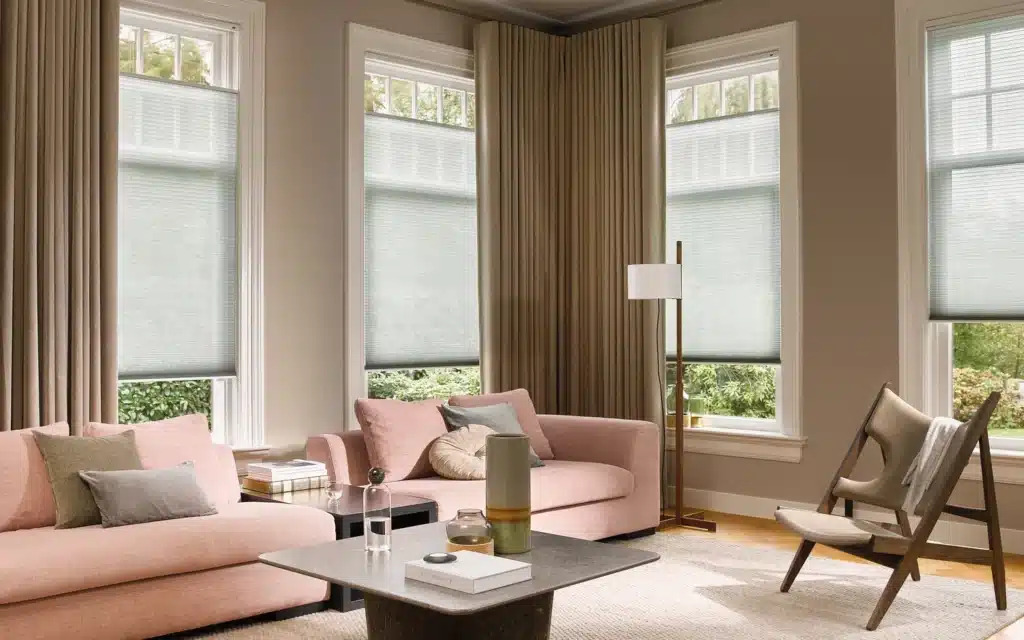 Green Deutte Shade Blinds in a cozy and contemporary living space with pink sofas. Installed by Complete Blinds.