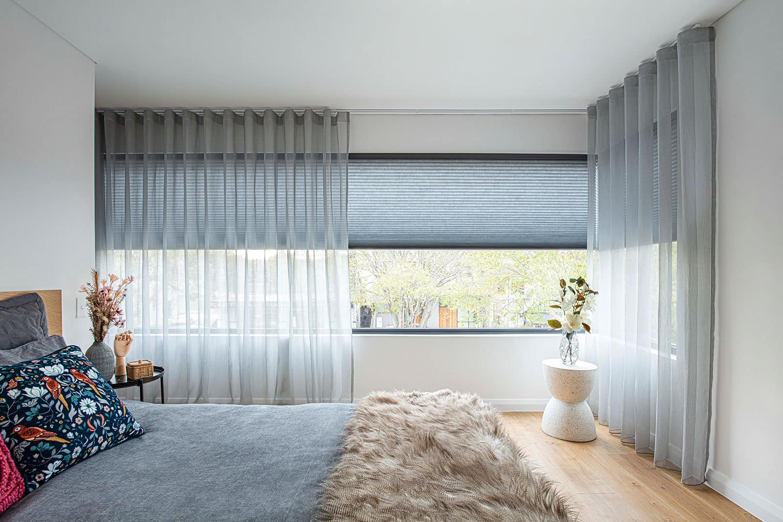 Modern cozy blue themed bedroom featuring Luxflex Sheer Curtains with Duette Shadings. Shutters with curtains combination.