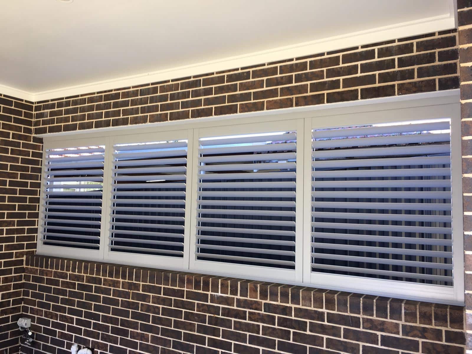 a window with shutters on it in a brick wall
