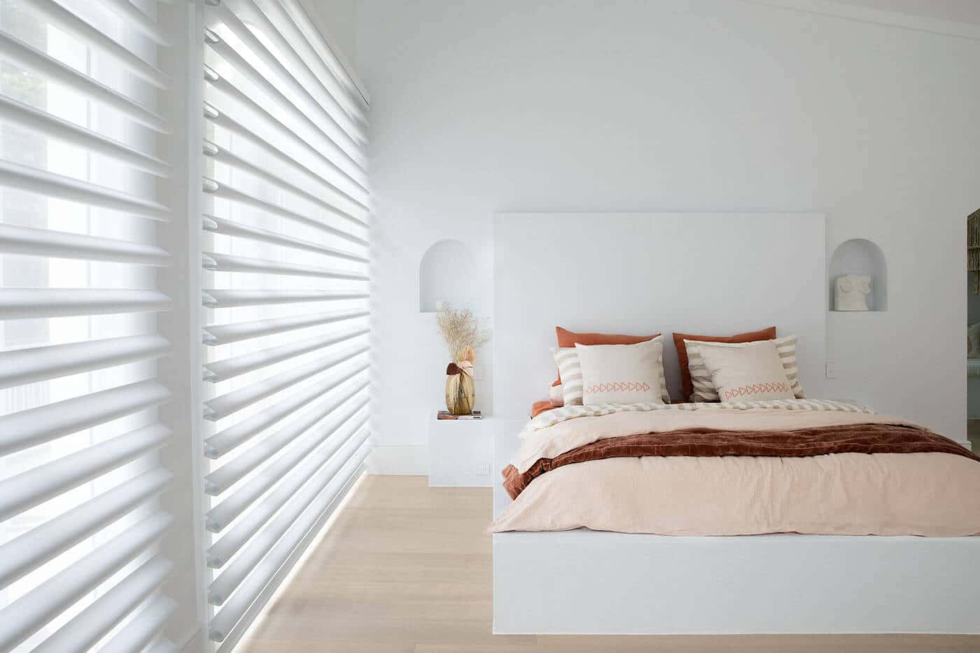 Pirouette Shades with softly curved fabric vanes allowing flexible light control and UV protection diffusing light in a cozy bedroom. Innovative and minimalist design. For sale at Complete Blinds Sydney.