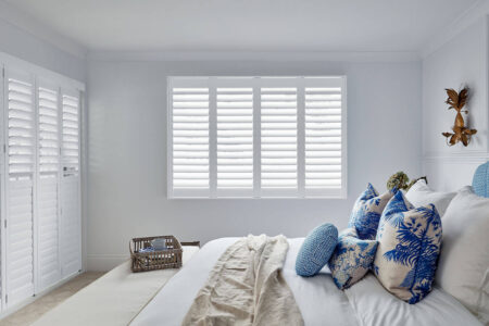 Cozy White Bedroom With Windows Covered By Motorised Polysatin Shutters, Made By Luxaflex. On Display In Our Sydney Showroom.