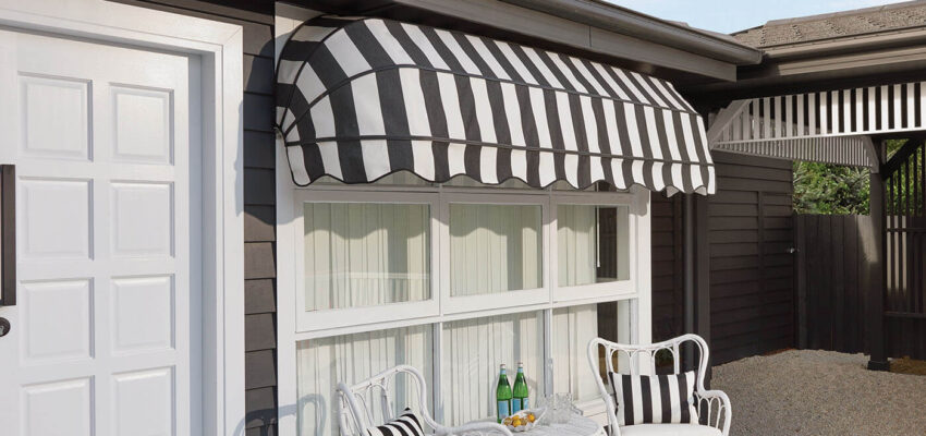 Outside View Of A Mid-century Style Home Featuring Luxaflex Awnings With Black And White Stripes Design Covering A Large Window Pane, Providing Shade.