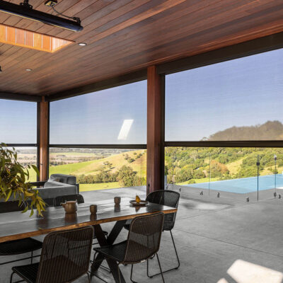 A Dining Room With A View Of The Pool And Mountains