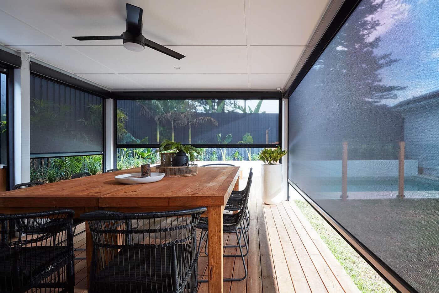 Modern home patio with dining area equipped with Evo Magnatrack Awnings by Luxaflex.
