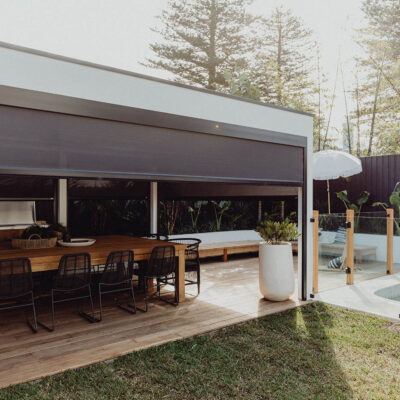 A Patio With A Table And Chairs Under A Shade