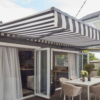 Patio Of Mid-century Home Style With Dinning Table, Covered By A Motorised Folding Arm Awning By Luxaflex. It Can Be Retracted Too. Made In Australia.