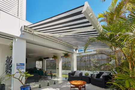 Modern Home Patio With Many Trees And Plants Featuring Luxaflex Folding Arm Awnings Which Can Be Extended Or Retracted Without Occupying Too Much Space. For Sale In Complete Blinds Sydney.