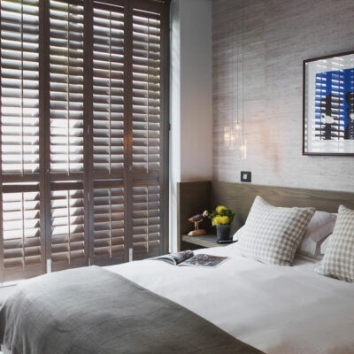 Brown Norman Normandy Shutters Made From Solid Timber In A Contemporary Bedroom. For Sale At Complete Blinds Sydney.
