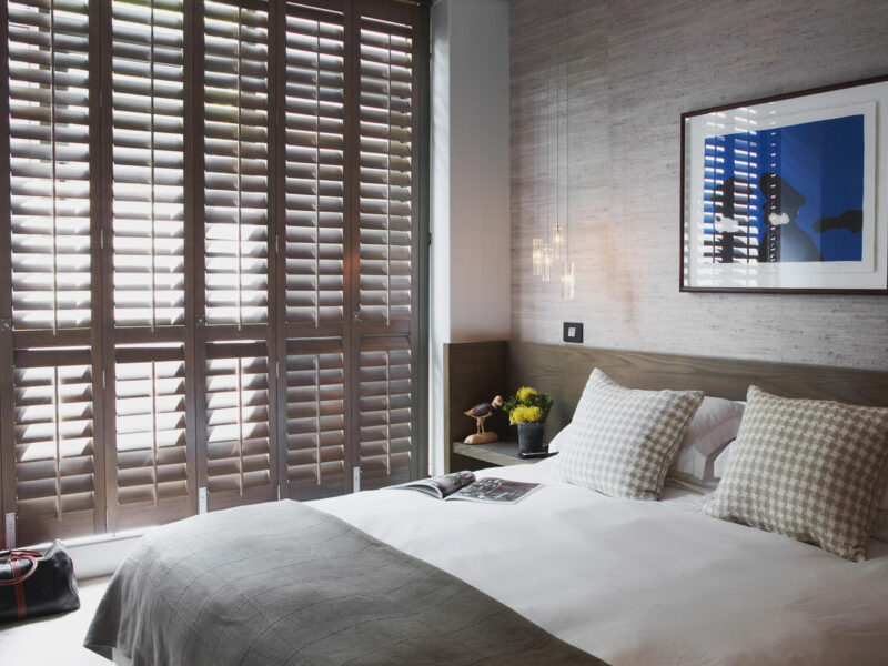 Brown Norman Normandy Shutters Made From Solid Timber In A Contemporary Bedroom. For Sale At Complete Blinds Sydney.