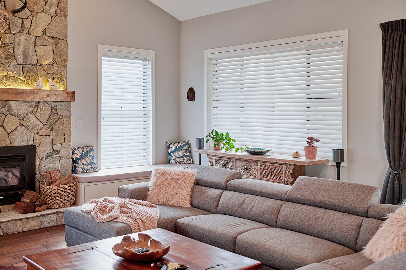 Modern farmhouse styled living space with large sofa and chimney, featuring Timber Venetian Blinds filtering our sunlight. Made by Norman. Made in Australia.