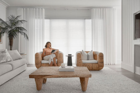 A Lady Enjoying Her Magazine In An Elegant Transitional-styled White Room With Wooden Floors And Furnitures, Featuring Luxaflex Silhouette Blinds In The Background Covering A Large Window. Shades On Display In Complete Blinds Sydney Showroom.