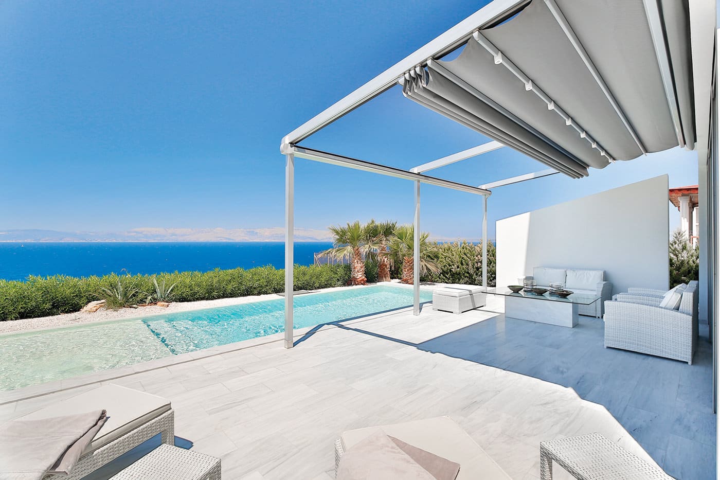 Home pool-side pergola with sea view featuring Palmiye Fabric Retractable Awnings by Luxaflex.
