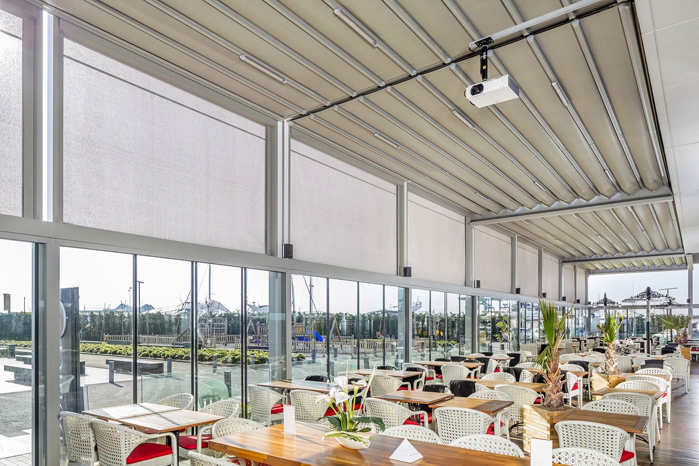 Rooftop commercial dining space installed with Palmiye Fabric Retractable Awnings by Luxaflex.