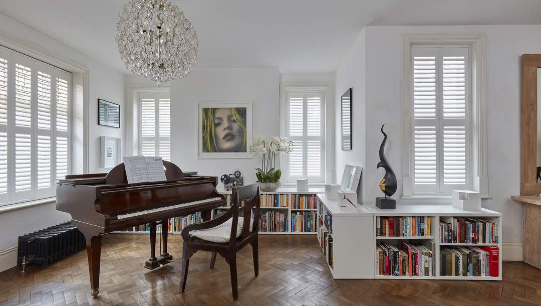 Modern contemporary themed living space installed with matching white Faux Wood window shuttes. By Complete Blinds. Choosing Shutters For Home: 5 Things To Consider.
