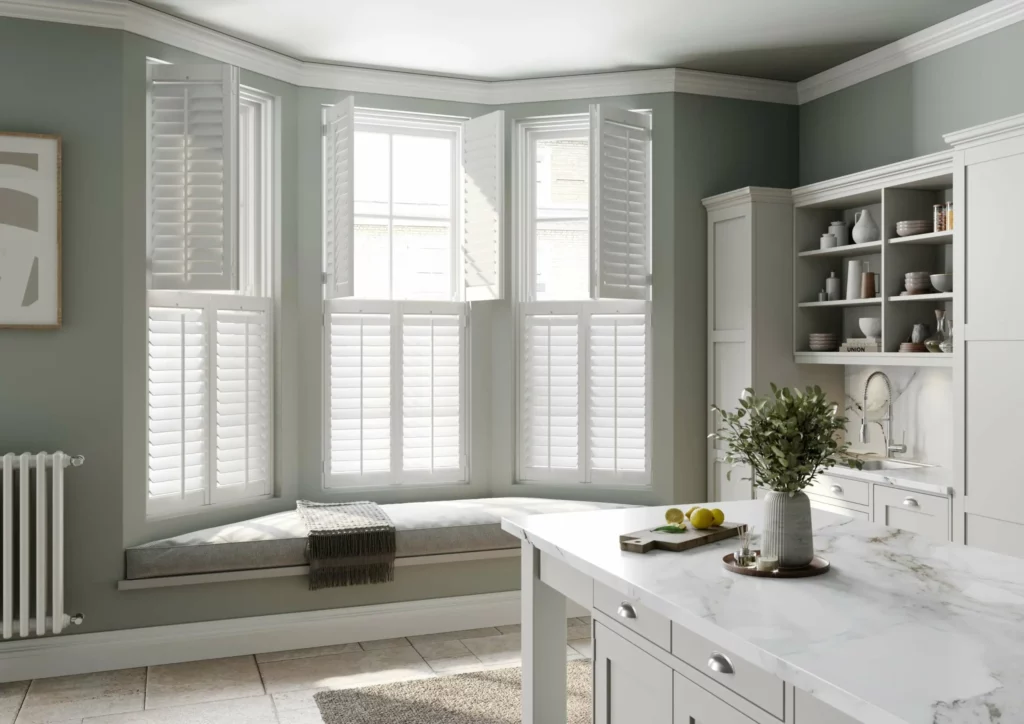 Bay window in French provincial kitchen installed with white window shutters by Complete Blinds Sydney. 